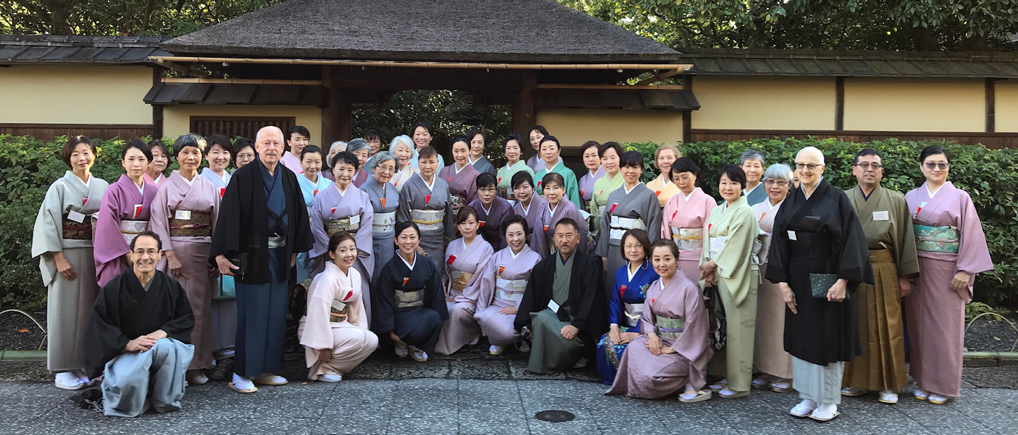 A group of tankokai members wearing kimono stand in front of Urasenke headquarters in Kyoto